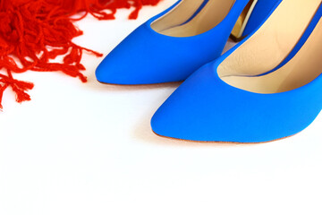 Women's blue pumps and a red scarf on a white background.