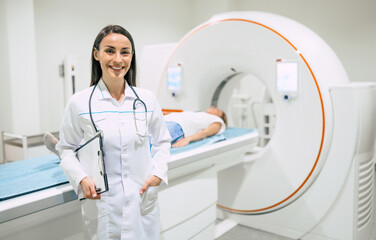 Confident female doctor oncology in magnetic resonance imaging or computed tomography room of a...