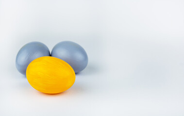 Banner: Three easter trendy decorated eggs yellow and gray lie on a white background with copy space for text Minimal easter style