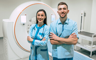 Two confident young doctors of oncology. Medical Equipment and Health Care. Magnetic resonance imaging scan or computed tomography device in modern Hospital.