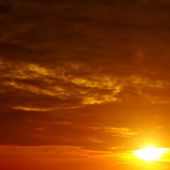 scenic of the strong sunrise and cloud on the orange sky.