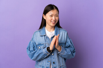 Young Chinese girl over isolated purple background applauding after presentation in a conference