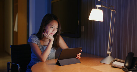 Woman use of tablet computer at night