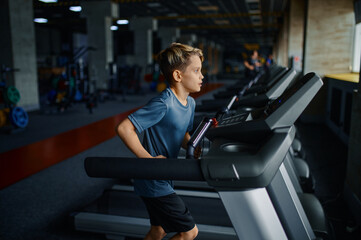 Obraz na płótnie Canvas Boy doing exercise on treadmill, running machine