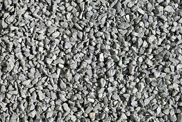 Monochrome light gray decorative pebbles used in the garden or yard. Background and texture