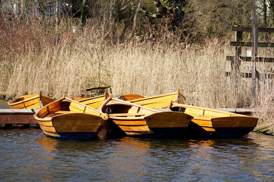 Ruderboote aus Holz, abgestellt auf einem See im Winter.