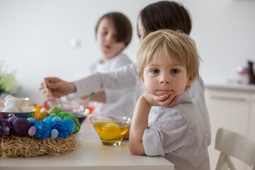 Children, boy siblings, coloring eggs for Easter