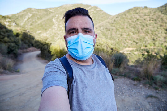 Man taking a selfie with a mask in the mountains