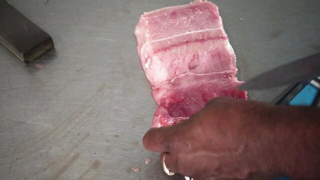 Close-up of hands slicing red fish fillets on cutting board, Fishmonger Chopping Fish