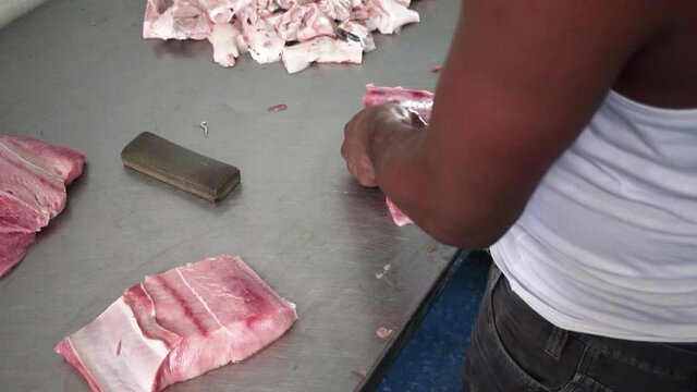 Afroamerican Male hands cutting fresh meat, Fishmonger Chopping and Selling Fish