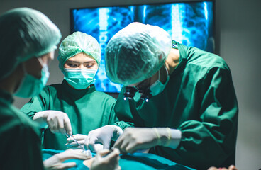 Surgeon doctor is wearing surgical gloves before the surgery in operating room.Asian doctor and an assistant in the operating room for surgical venous.