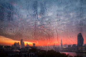 Beautiful landscape concept view of London City through glass window with streaks of rain and raindrops running down the glass