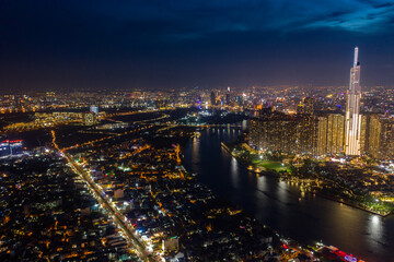 Fototapeta premium pic evening aerial panorama of Saigon, Ho Chi Minh City, Vietnam featuring all key buildings of the city skyline and the Saigon riverfront with beautiful light reflections on the calm water