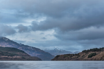 Fototapeta na wymiar Majestic landscape image across Loch Lomond looking towards snow capped Ben Lui mountain peak in Scottish Highlands
