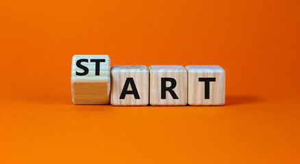 Start art symbol. Turned the cube and changed the word 'start' to 'art'. Beautiful orange table, orange background. Business and start art concept, copy space.