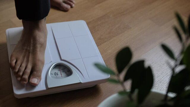 Asians foot man with body weight scales for measure weight loss.Weighing scale to healthy slimming concept.medium long shot panning dolling shift focus dolly slider for slow motion