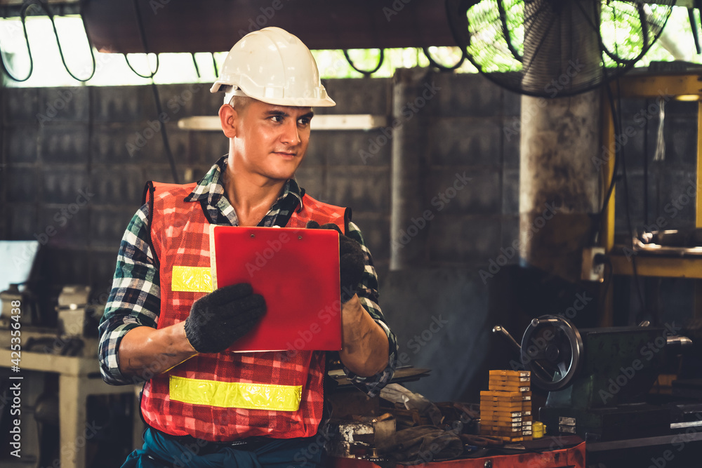 Poster manufacturing worker working with clipboard to do job procedure checklist . factory production line 