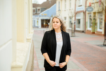 Sad businesswoman is walking through the empty downtown. Tired woman runs through the stat. Office work makes you tired. 