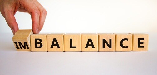 Balance or imbalance symbol. Businessman turns cubes and changes the word imbalance to balance....