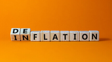 Inflation or deflation symbol. Turned cubes and changed the word inflation to deflation. Beautiful orange background, copy space. Business, inflation or deflation concept.