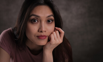 Close-up of a young woman with a satisfied facial expression - studio photography