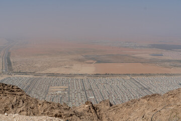 View of Al Ain, Abu Dhabi, United Arab Emirates from Jebal Hafeet looking at the red, orange and yellow sand and housing development.
