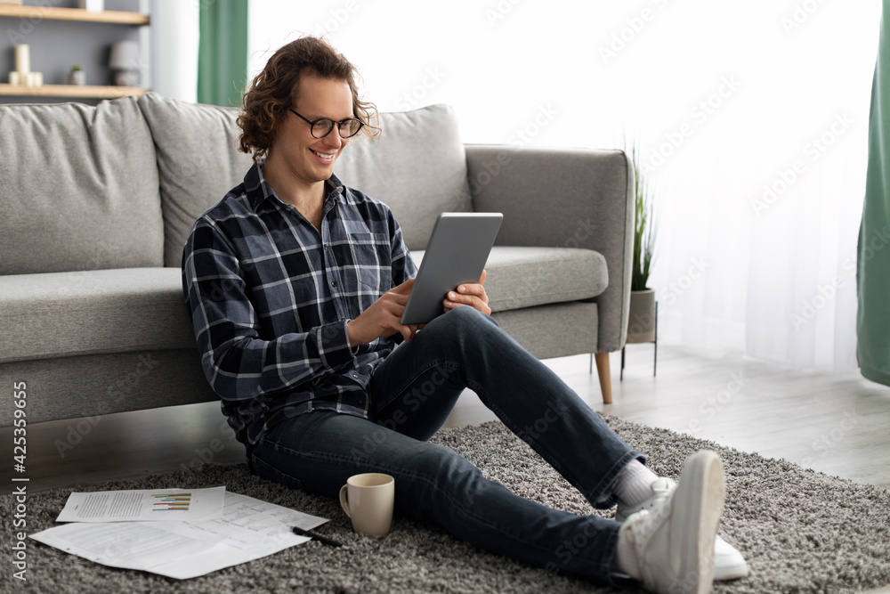 Poster Cheerful Man Using Tablet Computer Browsing Internet Sitting At Home