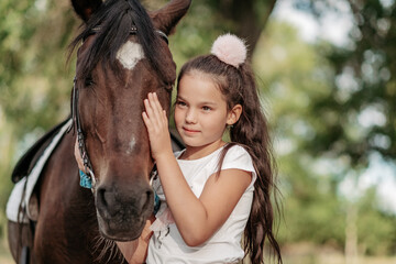 Emotional contact with the horse. Horse riding. The girl rides a horse in the summer.