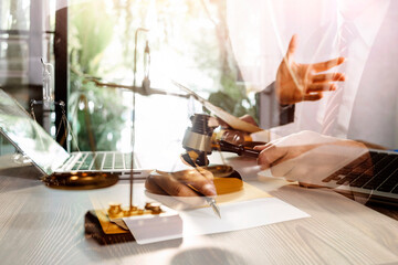 Business and lawyers discussing contract papers with brass scale on desk in office. Law, legal services, advice, justice and law concept picture with film grain effect