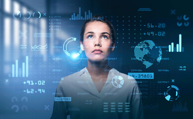 Young attractive businesswoman is looking at digital interface w