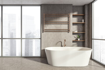 Bathroom interior with bathtub near window on concrete floor