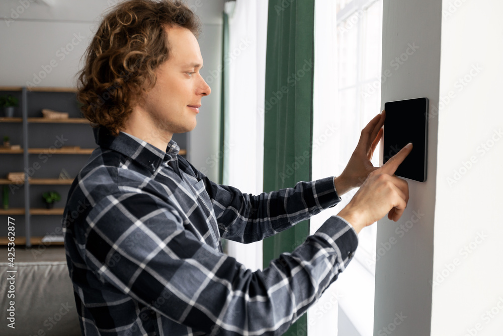 Aufkleber guy using tablet on wall with smart home application indoors
