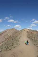 Fototapeta na wymiar Father and Son Climbing Hill Together at Dantes Peak, Death Valley, California
