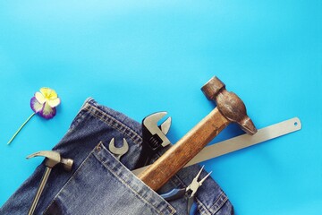 Father's day, tools in jeans pocket on a bright background, flower, concept of congratulations on the holiday, top view, copy space