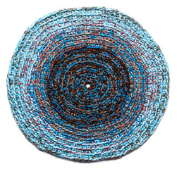 Round mat of blue color crocheted from thick threads. Isolated on a white background