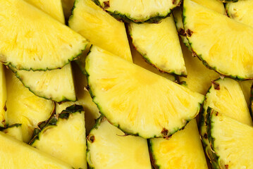 Pineapple juicy yellow slices background. Top view.