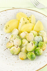 Boiled Brussels sprouts and potatoes on porcelain plate