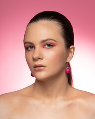 Lovely woman, round pink earrings and beautiful professional makeup