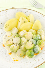 Boiled Brussels sprouts and potatoes with creamy sauce