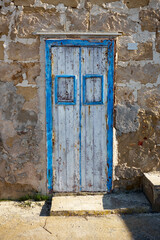 characteristic house with blue wooden doors and windows that are now old