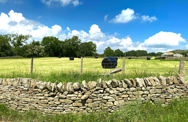 Rural scene, with bales of hay, dry stone walls, and outbuildings, on a sunny day in, Bradleys Both, Skipton, UK