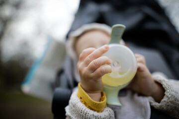 Shallow depth of field (selective focus) image with the hands of a baby boy holding a baby bottle.