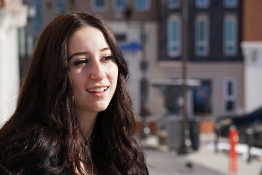 Smiling Girl in front of buildings