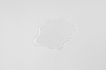Liquid water spill on white background, spilled water patch flat lay, top view