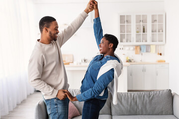 Obraz premium Portrait of joyful black couple dancing at home