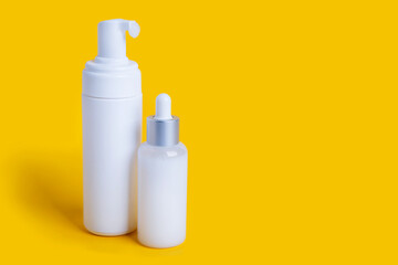 cosmetic bottles on yellow background with copy space
