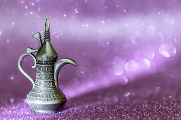 Arabic traditional coffee pot on purple glitter bokeh background