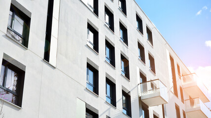 Facade of a modern apartment building. Glass surface with sunlight. Modern apartment buildings on a sunny day with a blue sky.