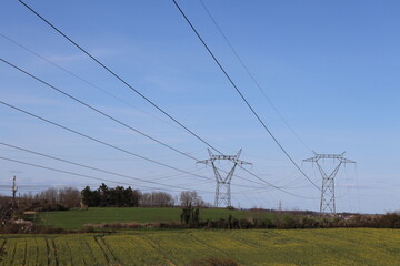 Pylônes électriques haute tension sur fond de ciel bleu, département du Rhône, France