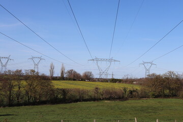 Pylônes électriques haute tension sur fond de ciel bleu, département du Rhône, France